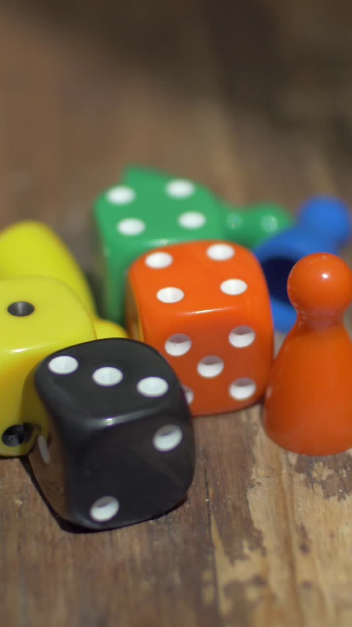 Primo piano di dadi colorati e pezzi di gioco da tavolo su un tavolo di legno