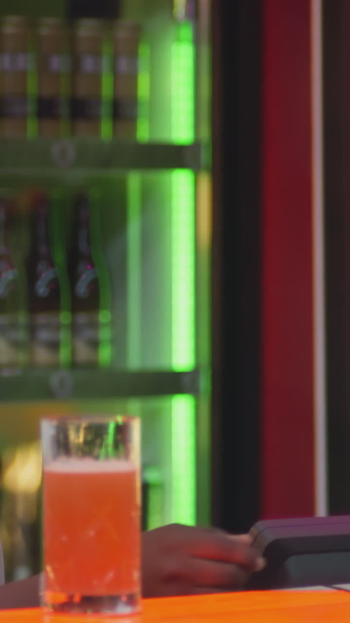 el barman barbudo da la factura al invitado en el mostrador de la barra. el barman sonriente prepara el cheque de pago para la mujer en el club nocturno. el tipo negro positivo trabaja en el pub