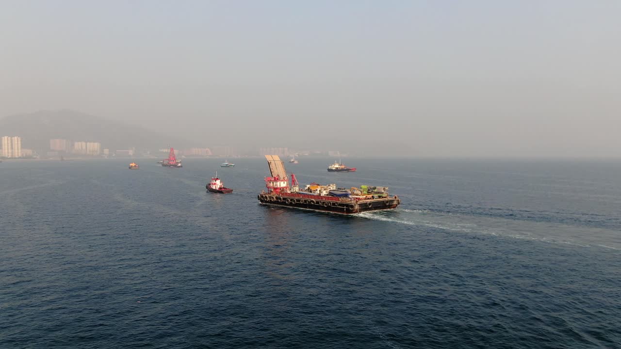 홍콩 만의 예인선으로 항구로 끌려간 콘크리트 믹서 트럭을 실은 바지선, 공중 전망