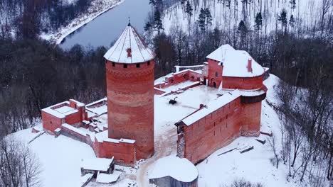 historic turaida castle stands, silent forest covered by fresh snowfall, latvia