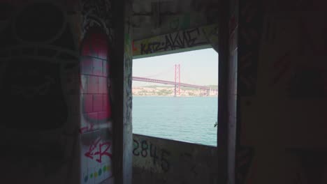 mirador abandonado con paredes de graffiti revela río y gran puente a través de la ventana