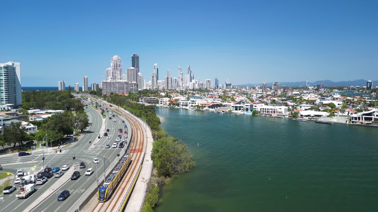 el moderno tranvía eléctrico viaja hacia el altísimo horizonte de los surfistas del paraíso de la costa dorada de queensland.