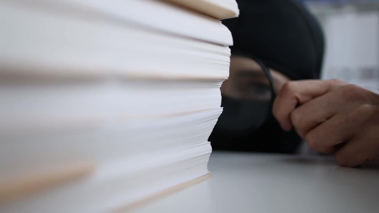 Thief in balaclava looking documents with magnifying glass 4k movie slow motion