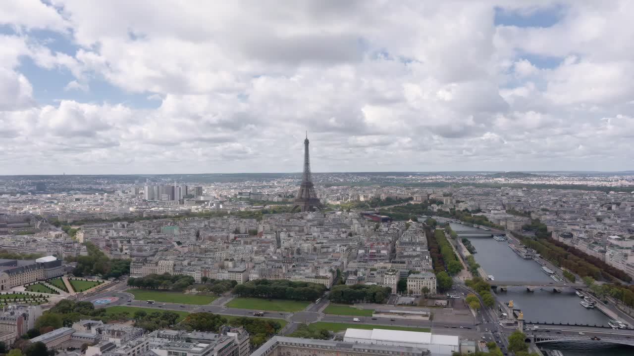 Stunning aerial drone shot flying towards the Eiffel Tower rising above Paris with the Seine River winding through the city’s historic skyline