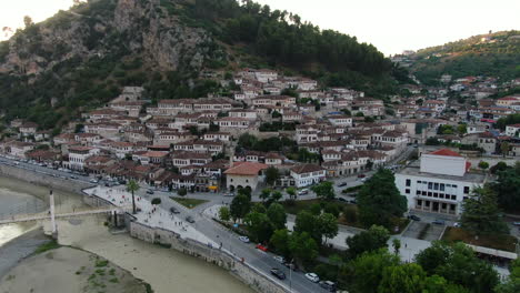 berat, city of albania: aerial view traveling out of the famous houses and their typical albanian windows and the gorica bridge during sunset