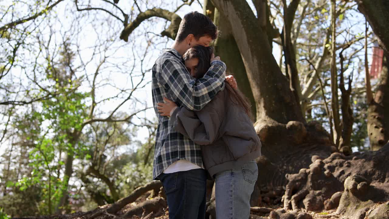 una pareja abrazándose en un parque.