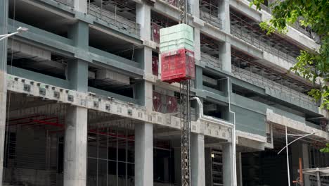 external lift moving down at construction site in downtown singapore