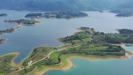 rama lake in bosnia and herzegovina with peninsula islands below, aerial pedestal lift shot wide view