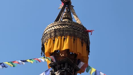 a close-up pan across the vibrant prayer flags adorning a stupa in kathmandu, capturing the intricate details and spiritual symbolism of these colorful banners as they flutter in the wind