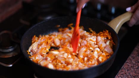 Cooking chicken and carrots in a frying pan