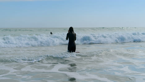 female surfer standing in the sea 4k