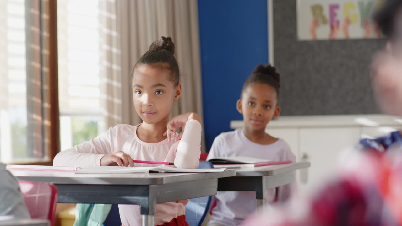In school, girls sitting at desks in classroom, paying attention to lesson