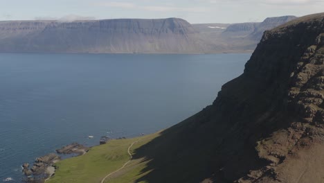 looking over mountains coming straight up from the sea in the westen fjords of iceland on a gorgeous sunny summer day