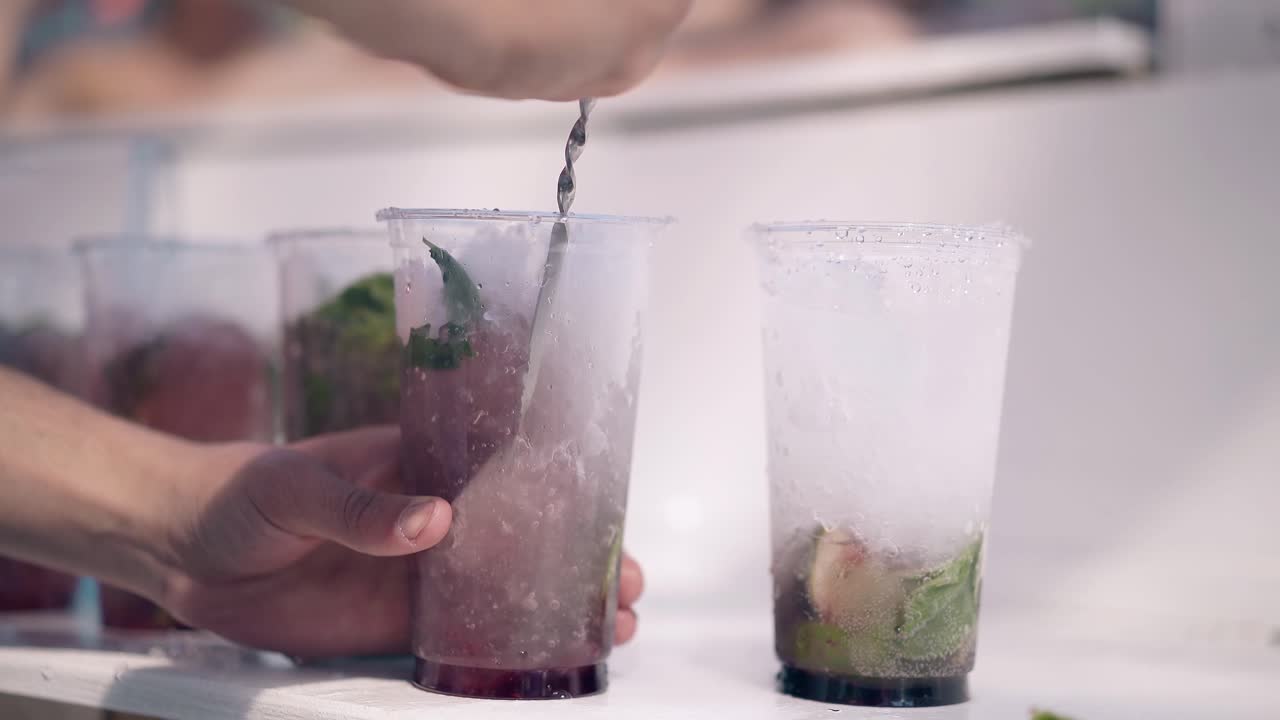 해변에서 여름에 바맨은 신선한  ⁇ 테일을 준비합니다.