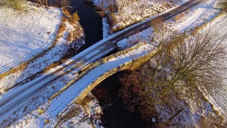 north york moors, packhorse bridge, castelton danby castle area, aerial dron footage in winter, rotation around bridge