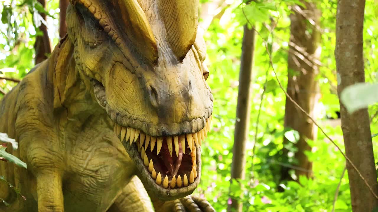 Animatronic dinosaur with open mouth in a vibrant, sunlit forest. The camera captures dynamic angles and vivid greenery