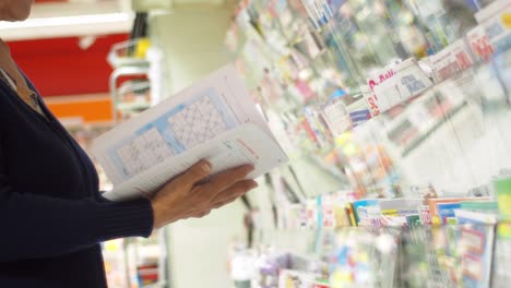 woman reading a magazine in a supermarket