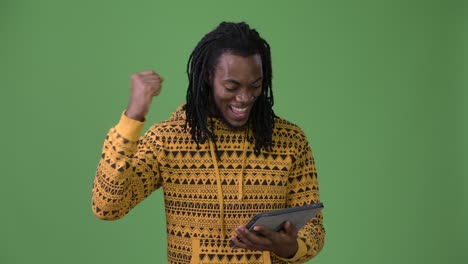 young handsome african man with dreadlocks against green background