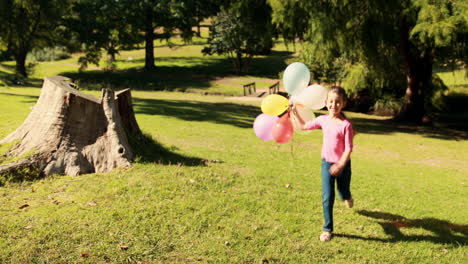 happy little girl holding balloons