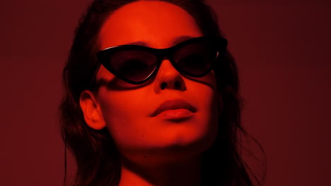 woman in red light with sunglasses