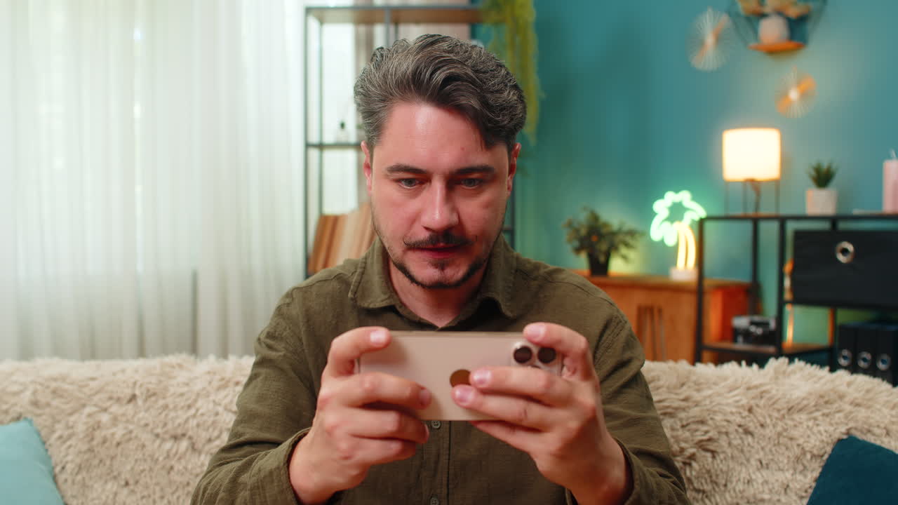 Middleaged man celebrates smartphone game jackpot pumps arms yelling woo victory excitement triumph