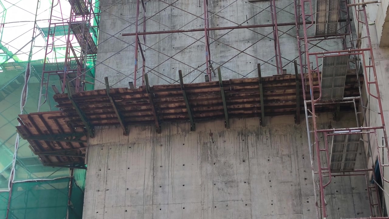 Una piattaforma di lavoro a sbalzo sostenuta da staffe per ponteggi su un edificio. Contiene impalcature aggiuntive utilizzate per la costruzione di muri esterni.