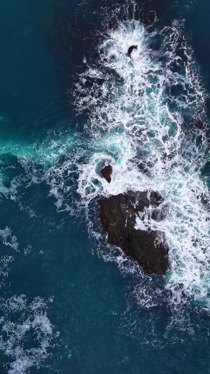 Onde che si infrangono contro affioramenti rocciosi in una serena vista costiera durante il sole di mezzogiorno