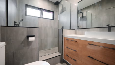 executive double shower with modern wooden cabinetry grey floor to ceiling tiles and full length mirror restroom interior