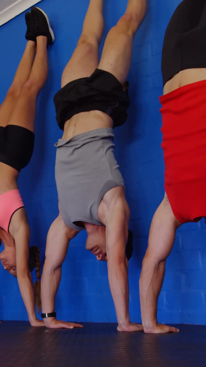 Personal trainer che assiste persone nell'eseguire una verticale