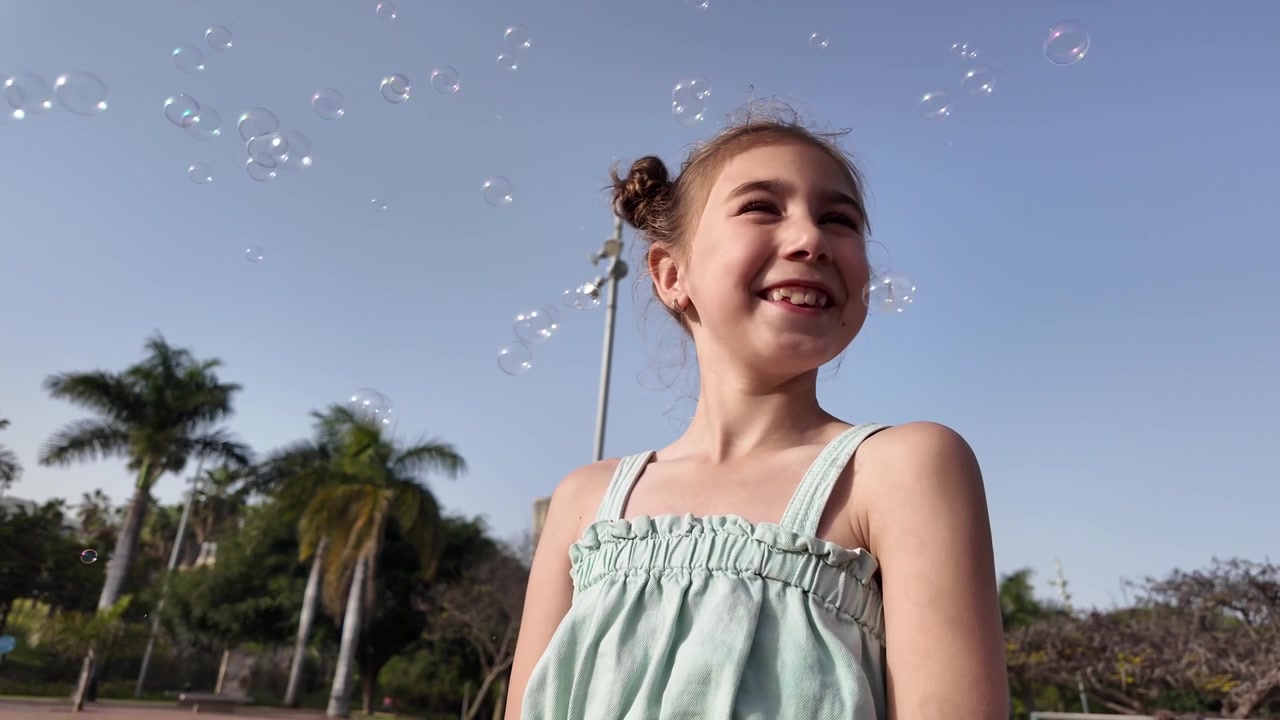 Menina brincando com bolhas de sabão sob a luz dourada do sol