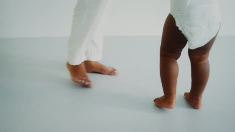 baby learning to walk with parent