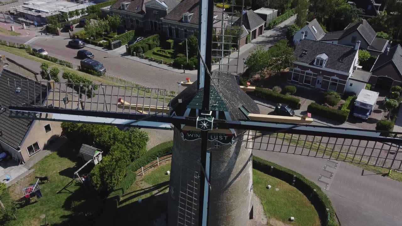 Drone flies to one of the blades of a Dutch windmill.