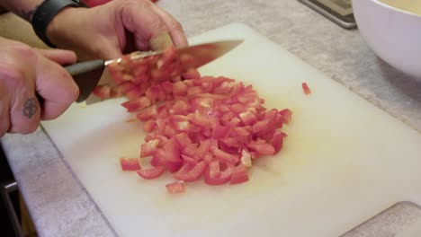 man chopping red bell pepper for cooking