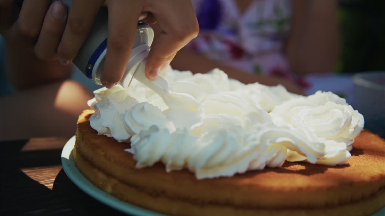 Delicious cake topped with whipped cream and decorative frosting on a sunny outdoor table