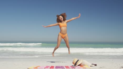 African-american-woman-jumping-at-beach-
