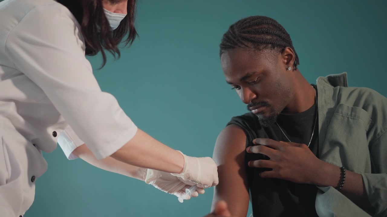 Une infirmière administre un vaccin. Un professionnel de la santé propose une séance de vaccination calme. Une infirmière compatissante guide attentivement un patient masculin à travers la vaccination dans un cadre de proximité avec réconfort.
