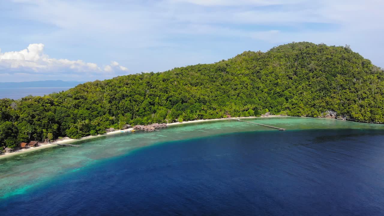 bosque verde, playa y bungalows en la isla de kri en raja ampat, indonesia