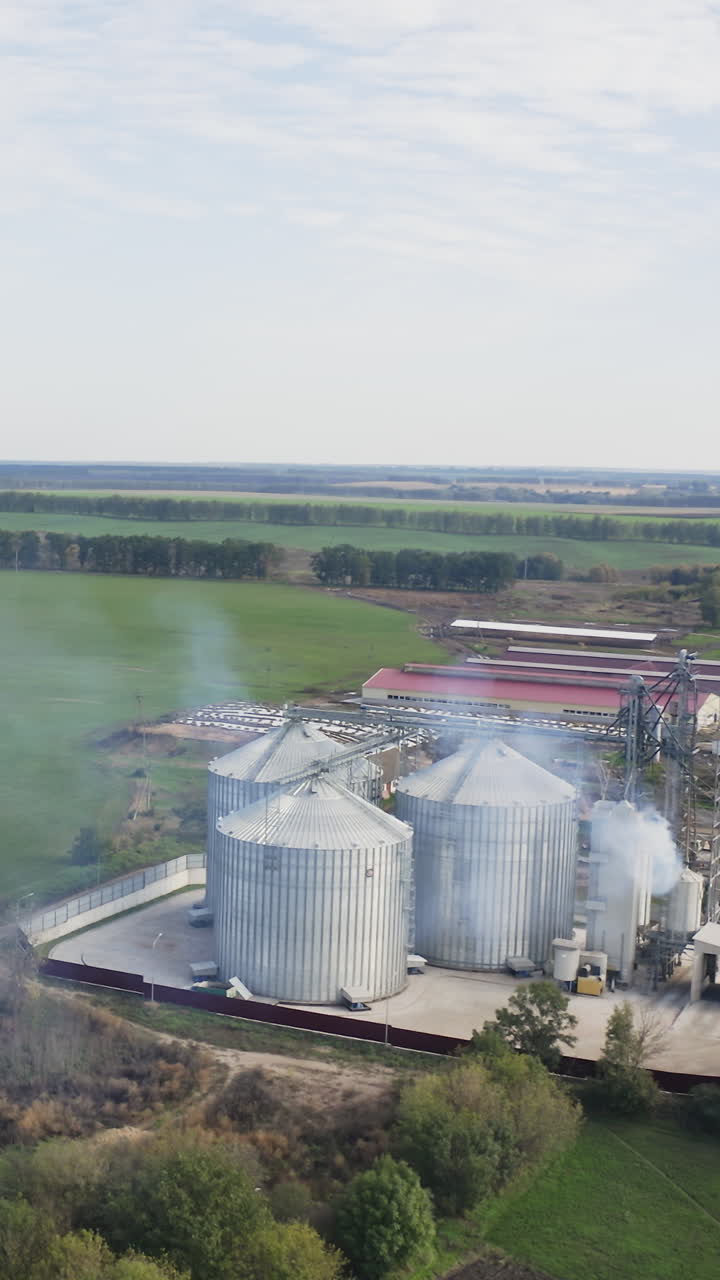 Tanks granary farming elevator. Factory agricultural elevator aerial view. Vertical video