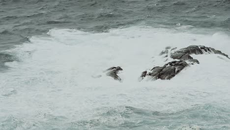 Extreme-waves-splashing-over-rocky-island-near-Norway,-slow-motion