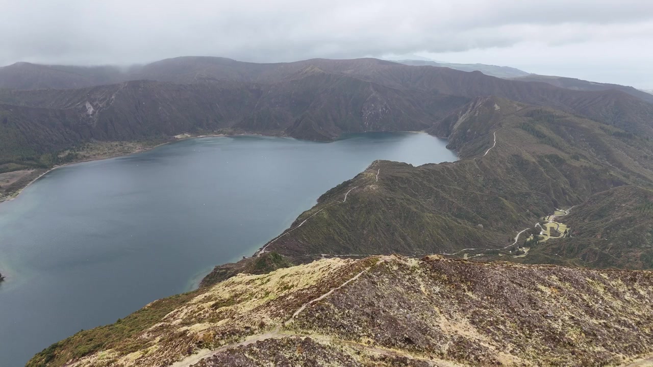 Vista aérea tranquila da protegida Lagoa do Fogo em uma cratera vulcânica em São Miguel, Açores. Imagens de drone da água turquesa e praias de areia cercadas pela natureza selvagem.