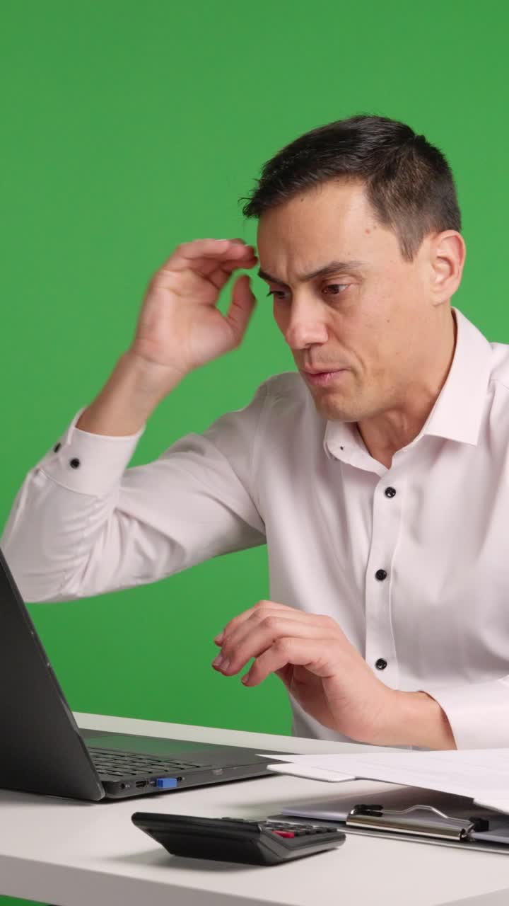 Office worker reacting with surprise and perplexity at laptop on green screen