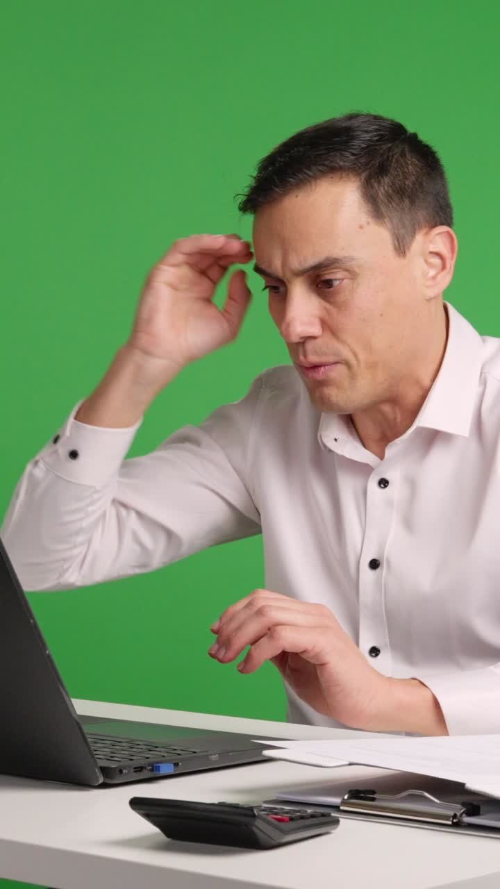 Office worker reacting with surprise and perplexity at laptop on green screen