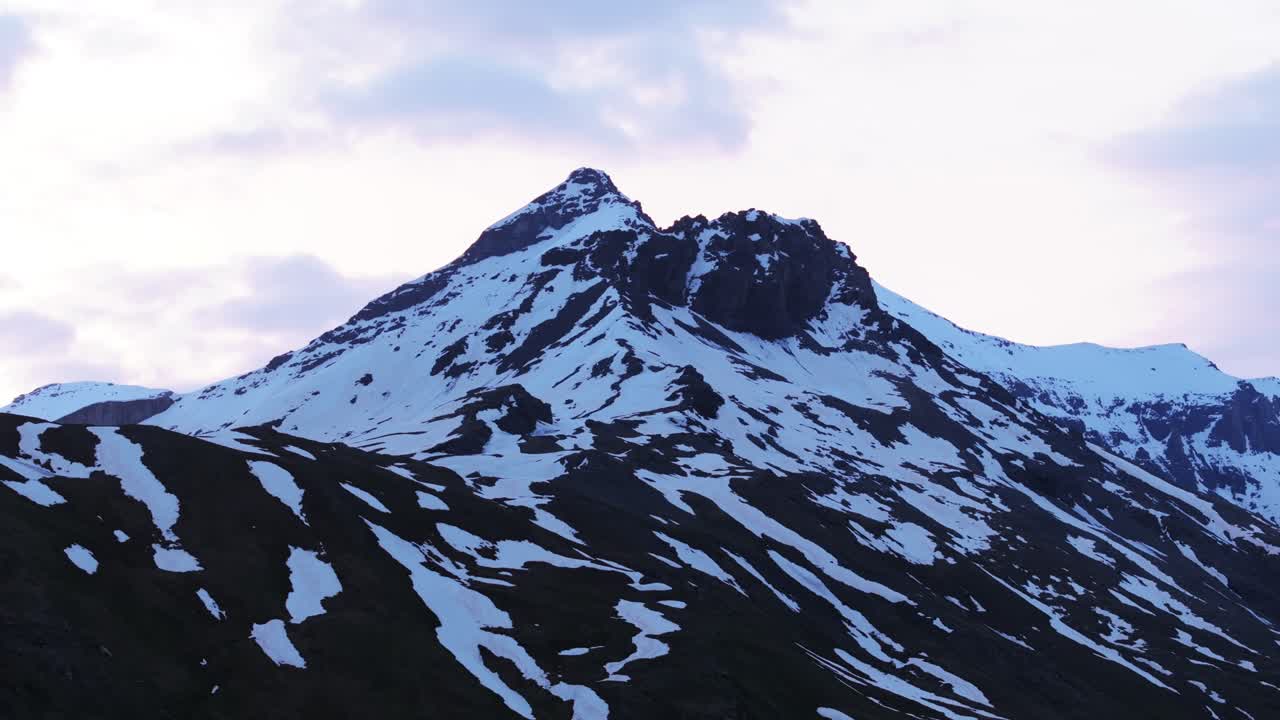 Maestosa cima montuosa innevata con cielo al tramonto, Moncenisio, Alpi francesi, riprese aeree