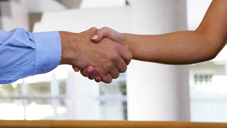 executives shaking hands in conference centre