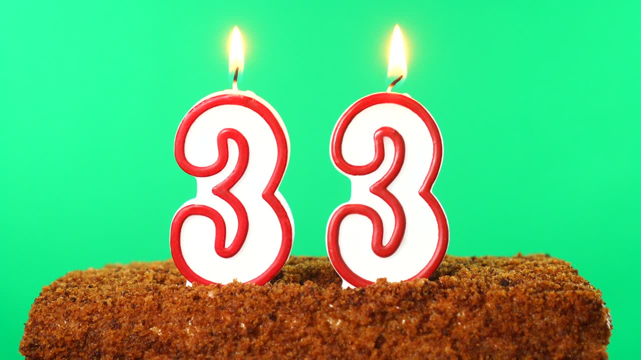 pastel con el número 33 vela encendida. llave de croma. pantalla verde. aislado