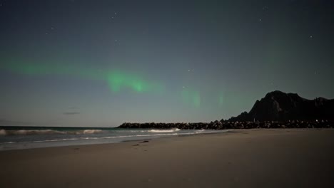 northern lights over the beach in vestarelen, norway, captured in a timelapse.