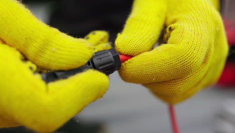 connecting electrical wires with yellow gloves