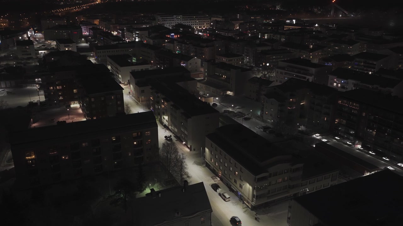 Ripresa con drone sopra edifici residenziali illuminati in una notte d'inverno a Rovaniemi.