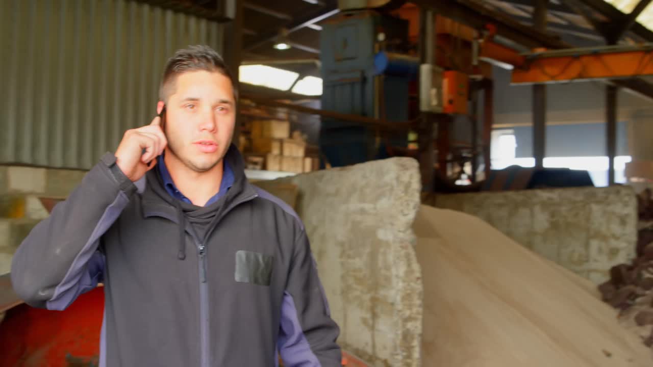 trabajador hablando por teléfono móvil en el taller 4k
