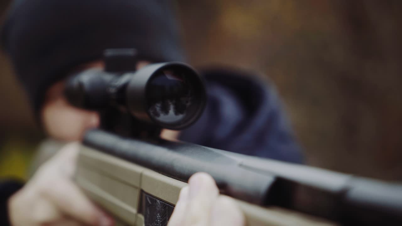 Hunter with gun on forest. Close up of the hunter man shooting with hunting rifle on nature